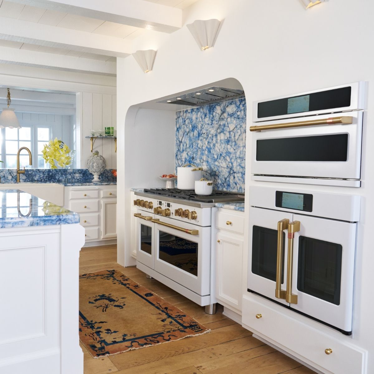 Kate Hudson's kitchen with white cabinetry, blue backsplash, and matte white appliances.
