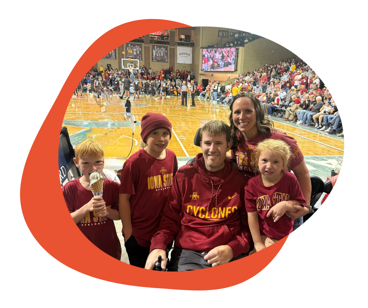 A family poses together at a basketball game.