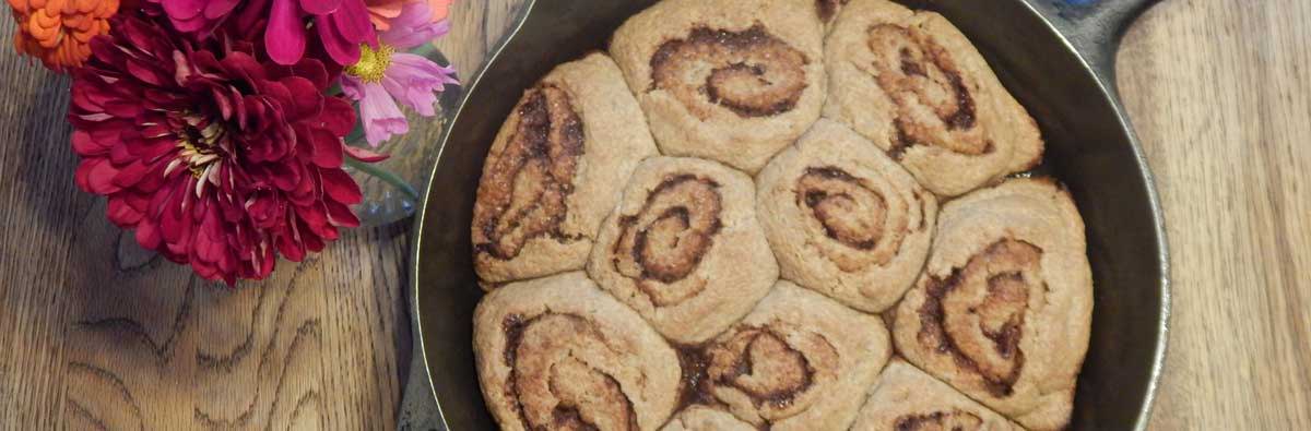 Overhead view of cooked cinnamon rolls in a cast iron skillet