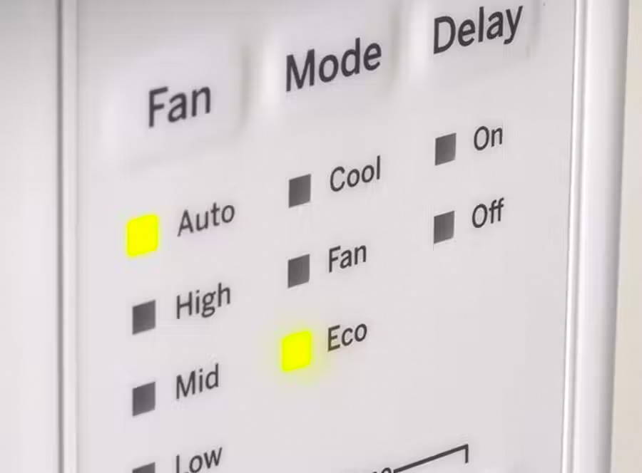 Front of window ac control panel showing the Eco Mode light is lit up.