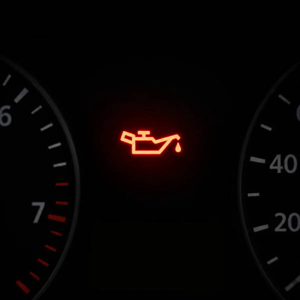 Oil warning light illuminated on a car dashboard.
