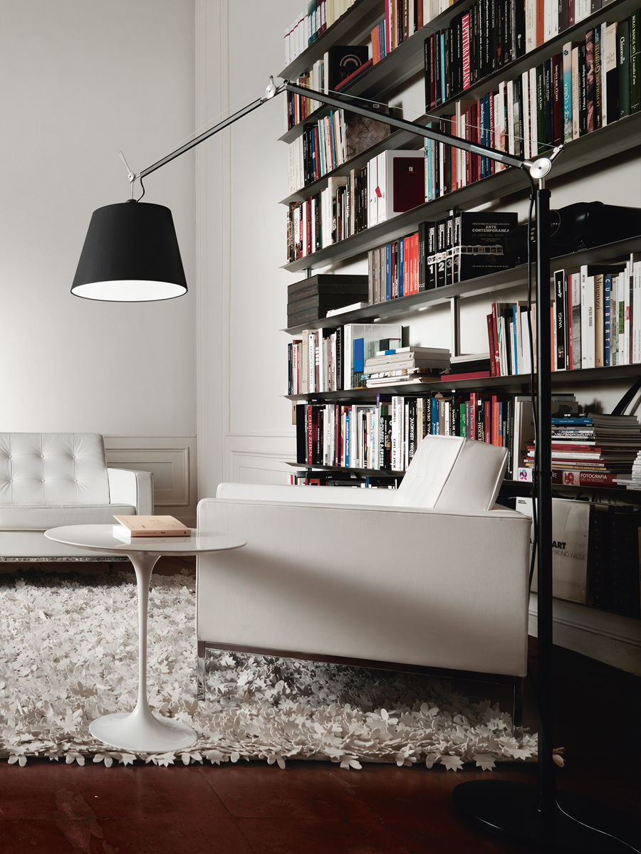 Modern living room with a white sofa, lamp, and bookshelf.