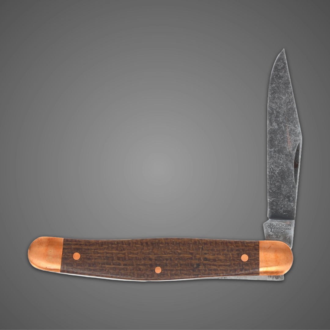 A folding knife with a wooden handle against a gray background.