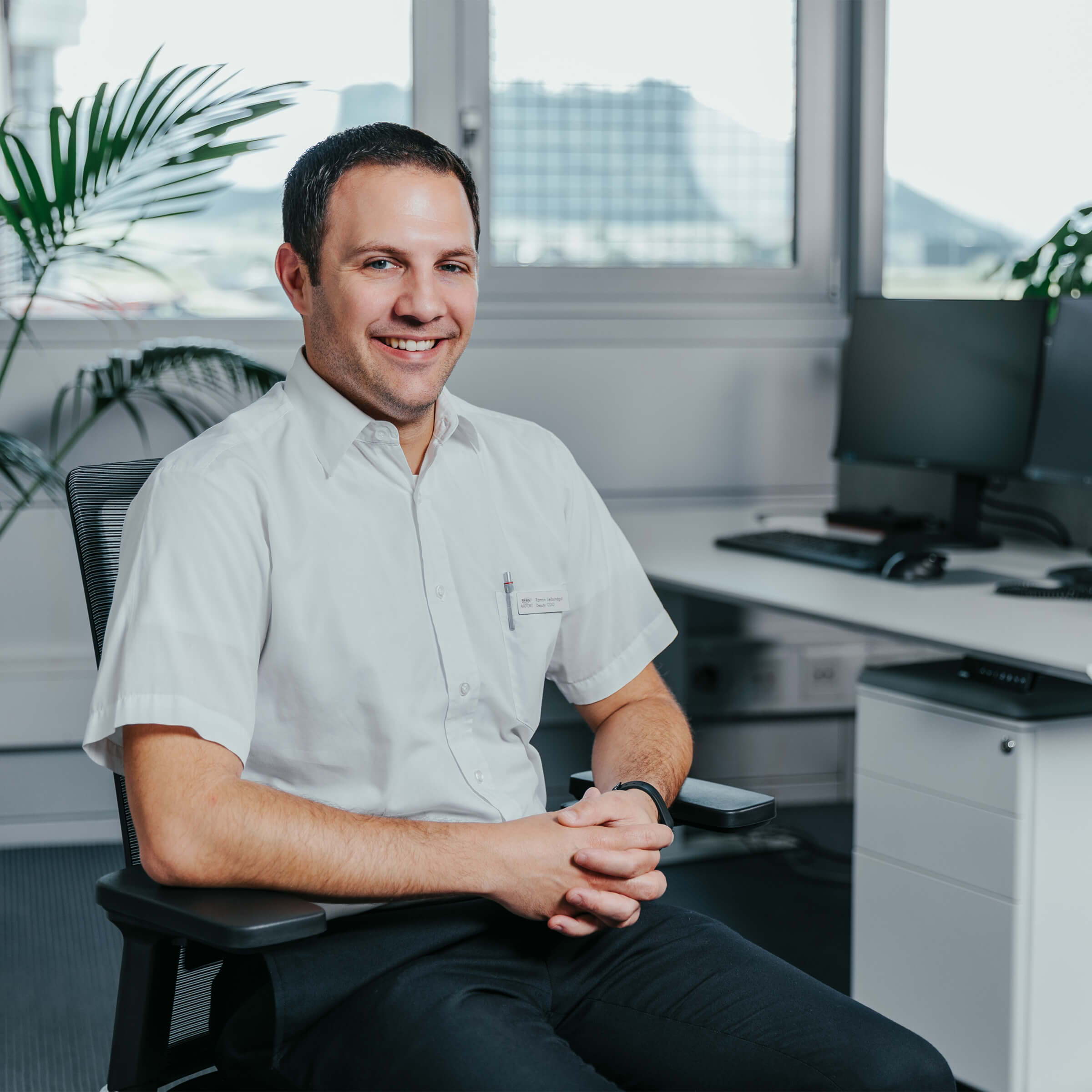  Freundliches Portrait von Ramon Leibundgut, Deputy COO am Flughafen Bern Belp, der auf einem ofinto Bürostuhl Active sitzt und sich bereit macht für sein Interview. 