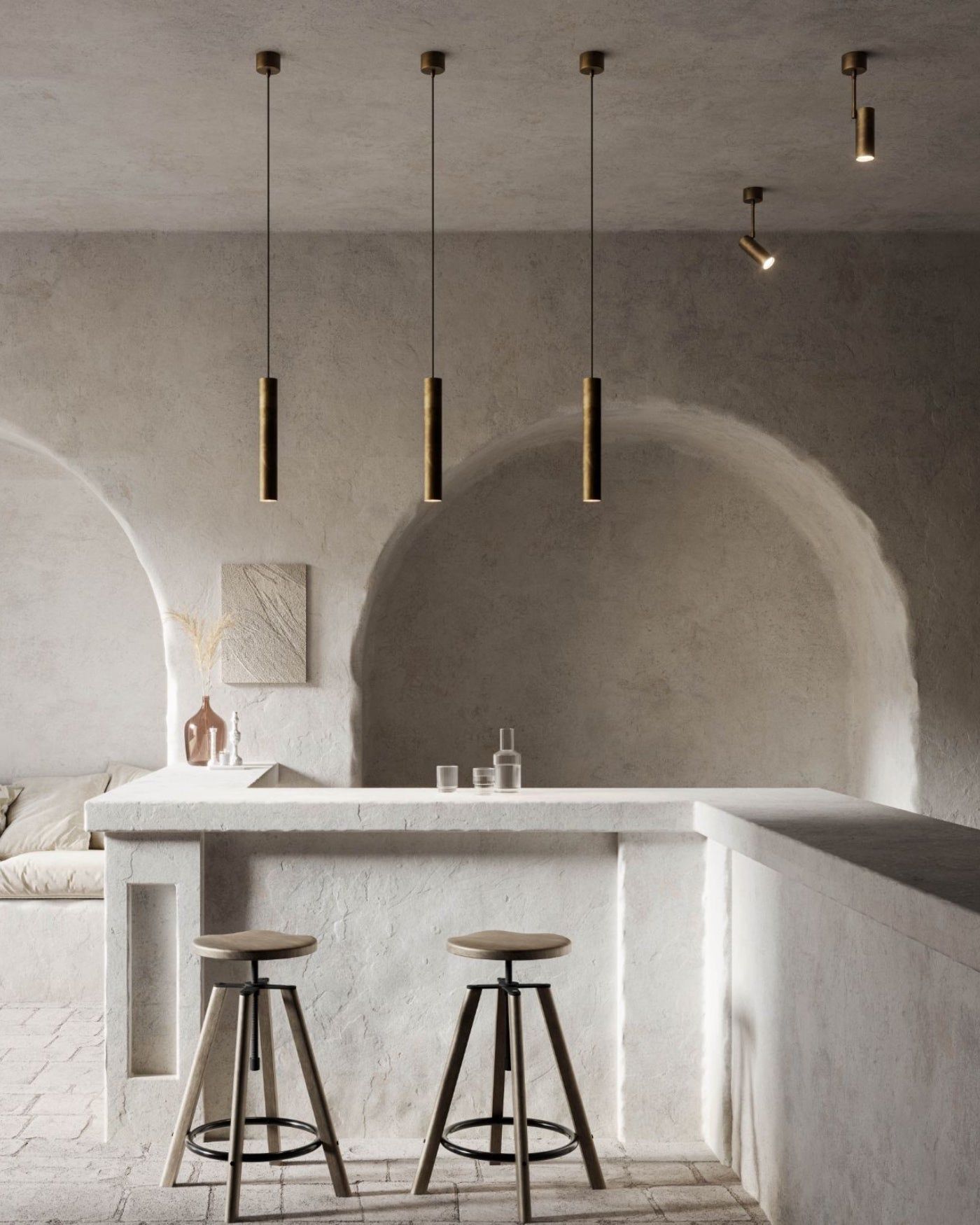 Three antique iron cylindrical pendant lights hanging over a minimalist kitchen counter