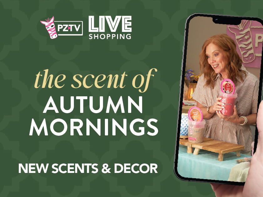 Woman holding a phone showcasing autumn scents and decor for live shopping event.