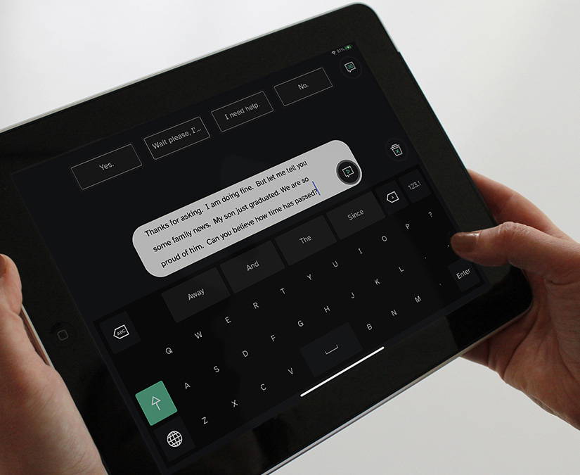 Person using their hand to communicate on a Tobii Dynavox assistive technology device 