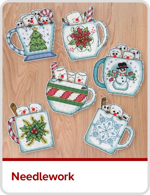 Six decorated mugs with marshmallows and holiday designs on a wooden background.