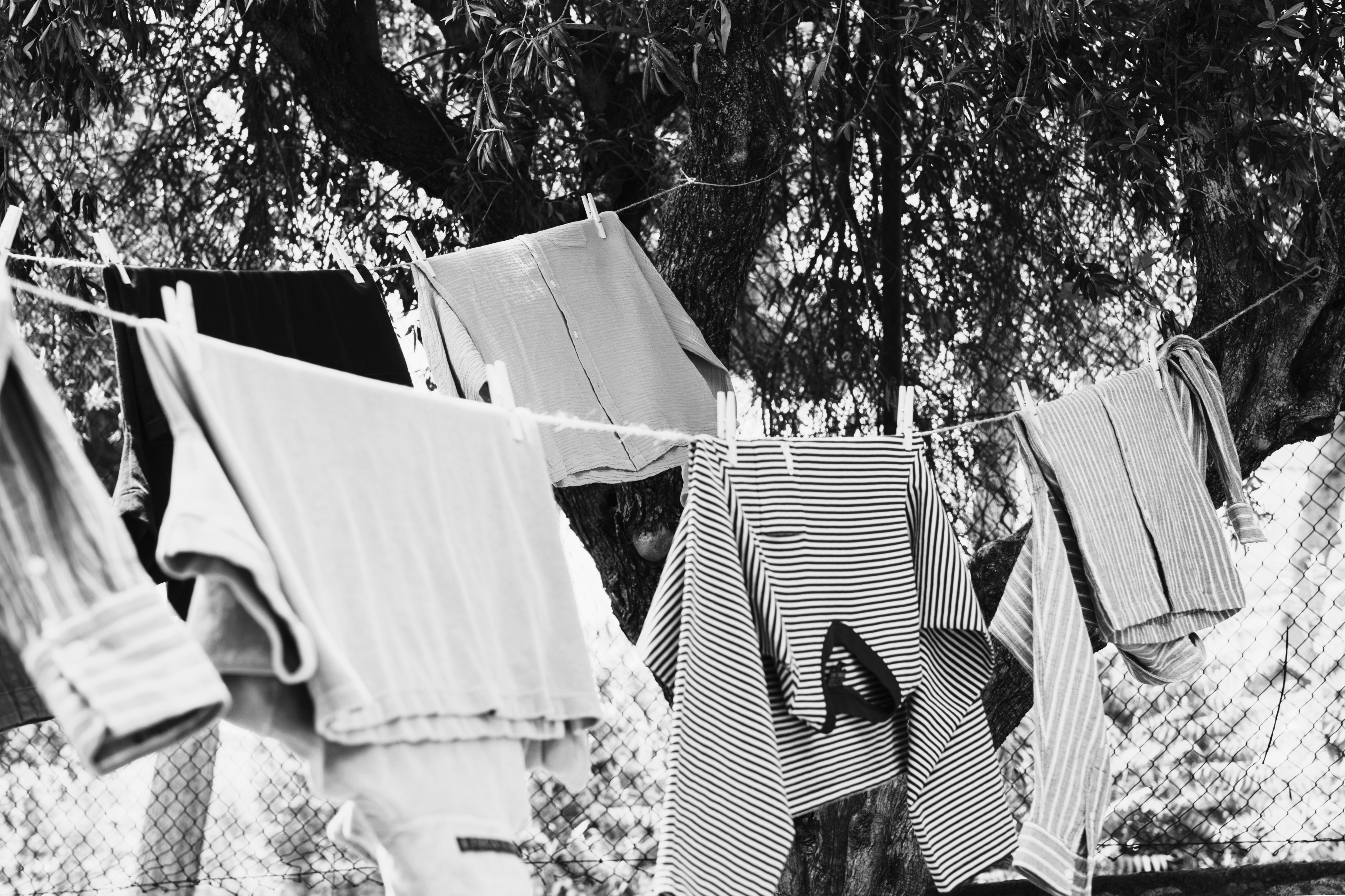 Black and white photo of clothes hanging on a line outdoors.