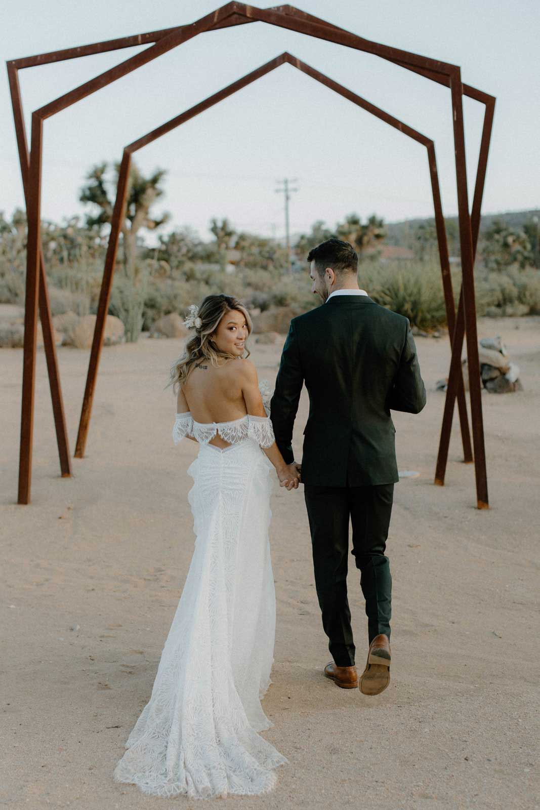 Bride and Groom walking through archways