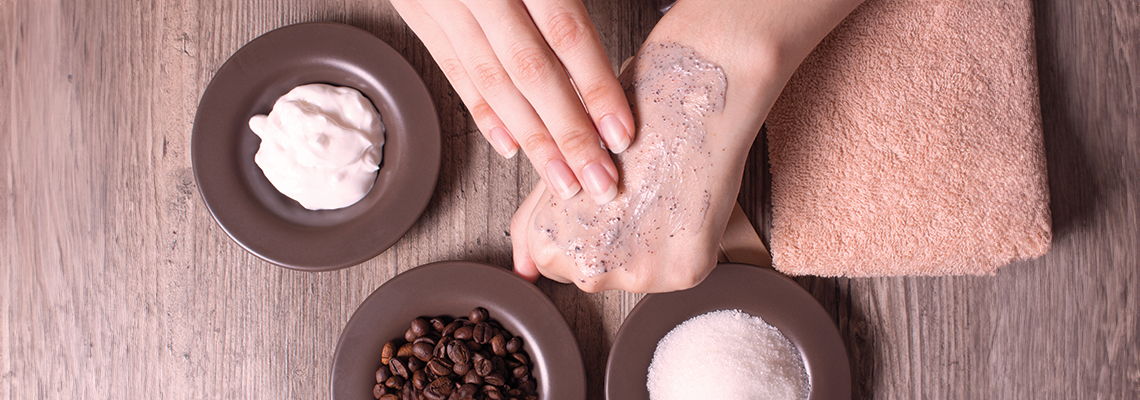 Person applying skincare product with bowls of ingredients nearby.
