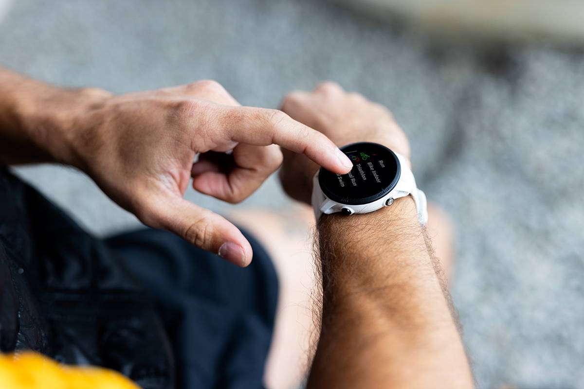 A runner using the touchscreen on the Forerunner 955 premium multisport watch