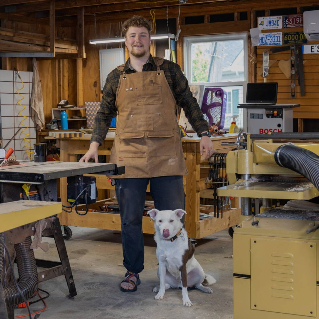 maker and resin artist eli tomalka and his dog standing in their woodworking shop