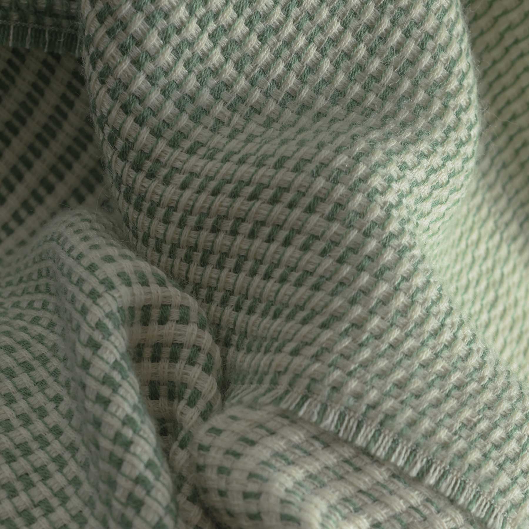 Close-up of textured fabric in green and white patterns.