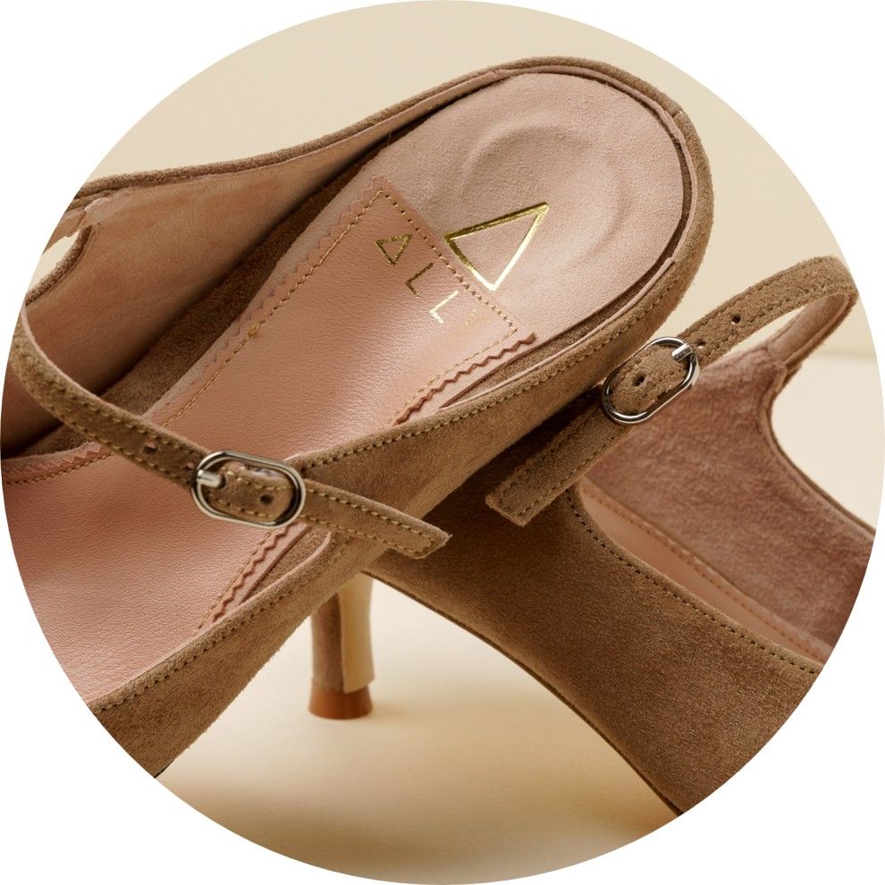 Brown high-heeled shoes with ankle straps on a light background.