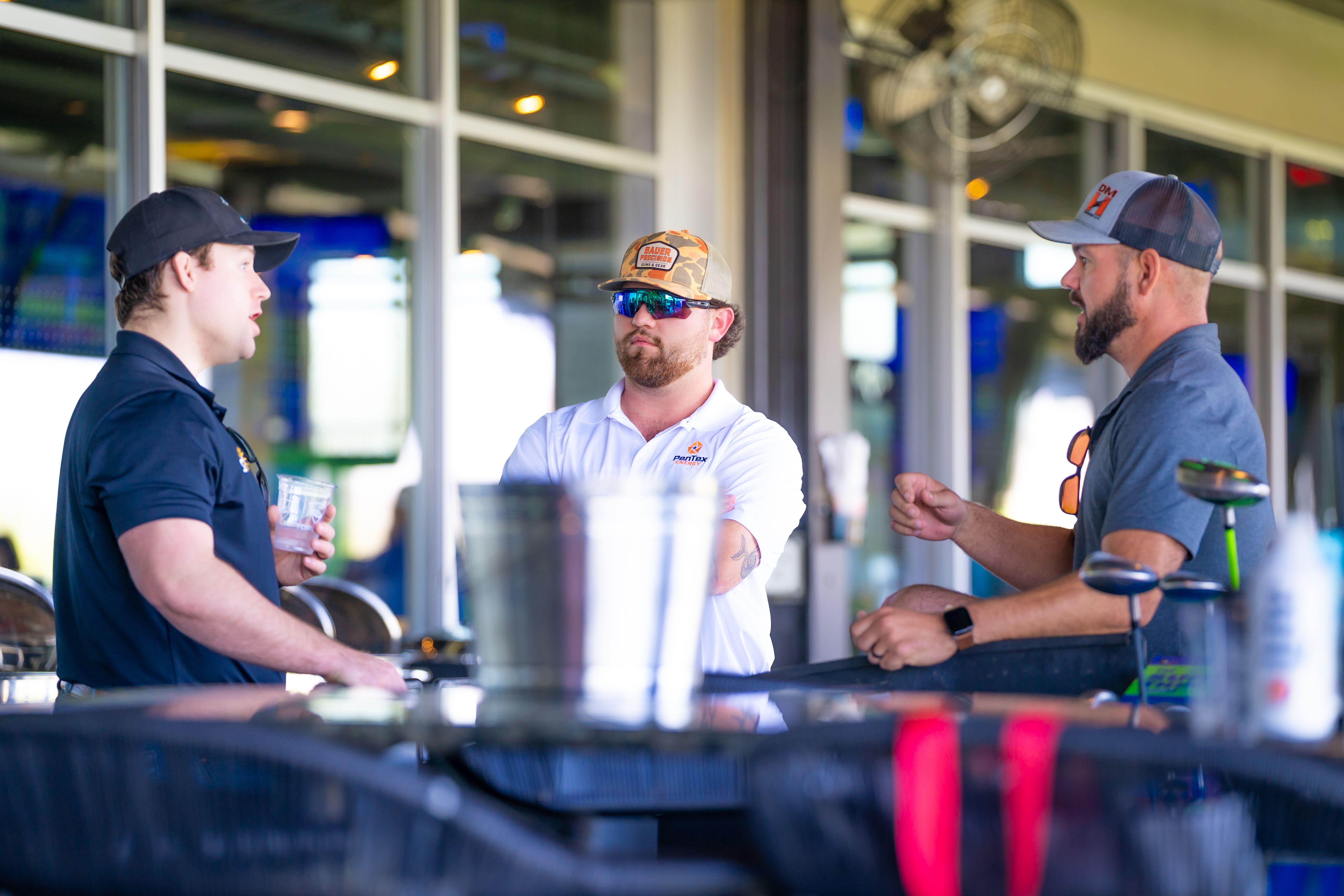 Three men chatting at a table.