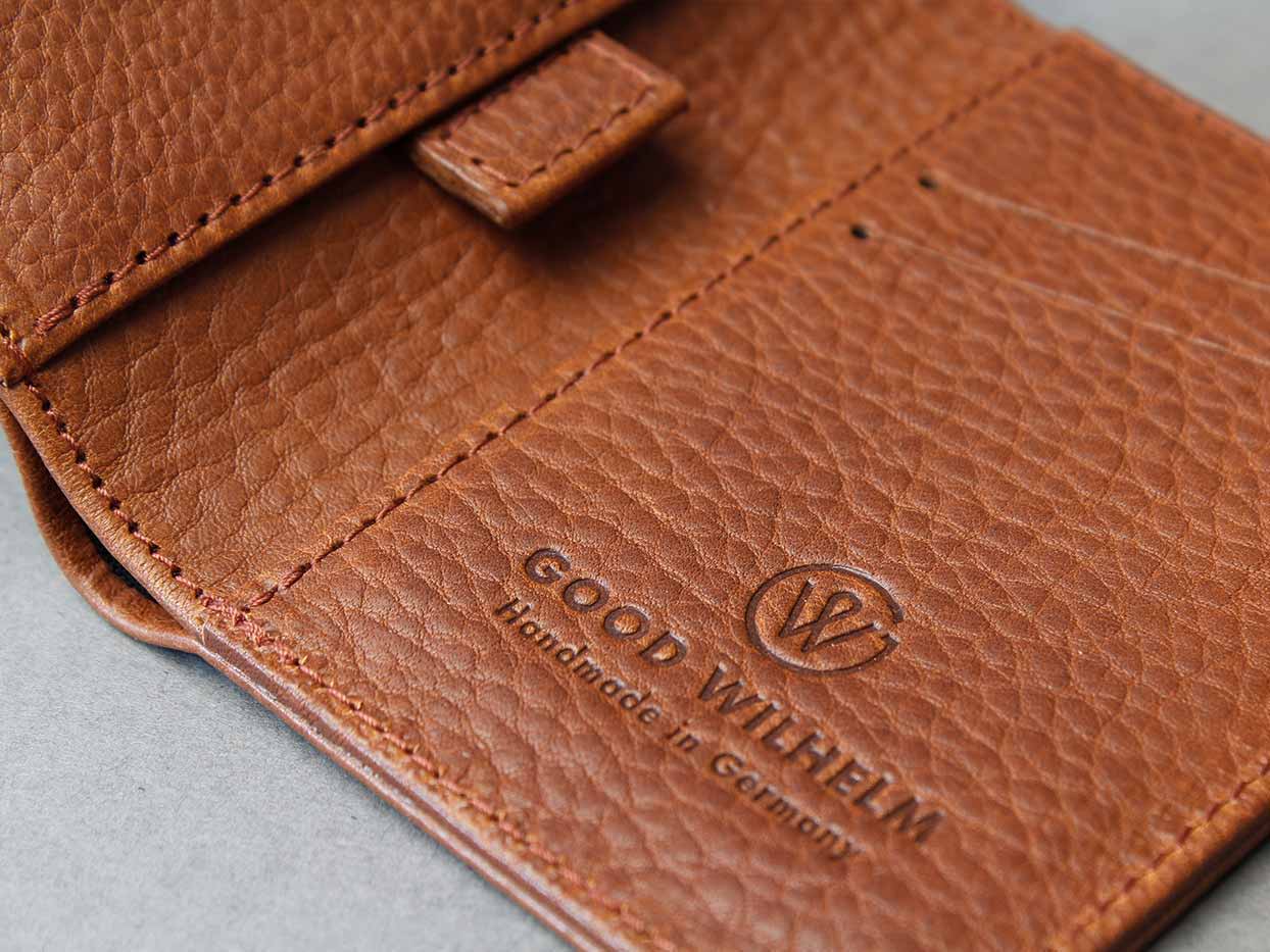 Aufgeklapptes Leder Portemonnaie von GOOD WILHELM mit einem Brennstempel logo