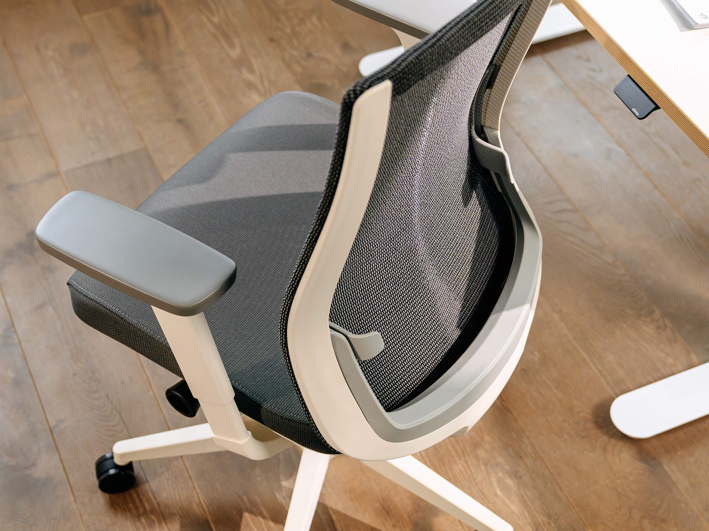 Weisser Bürostuhl ofinto Ergo schräg von oben in einem gemütlichen Home-Office mit modernem Holz-Boden