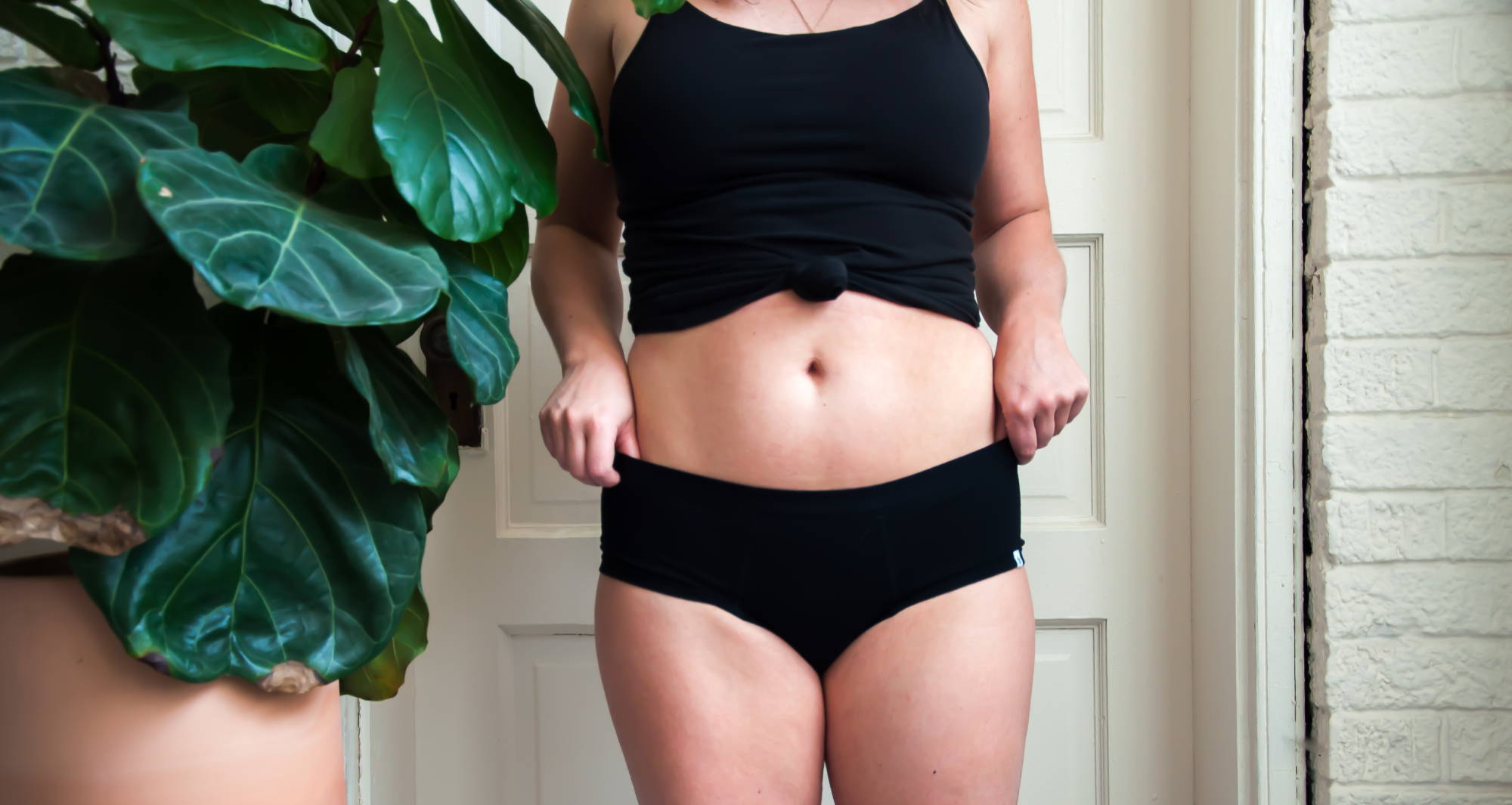 Woman standing in black WAMA underwear knowing how to prevent camel toes.