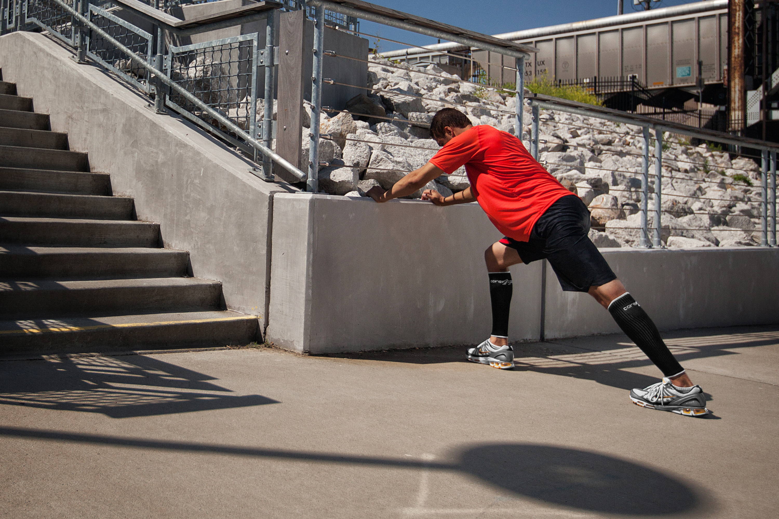 man stretching during his exercise, man wearing Core-Sport compression leg sleeves while exercising