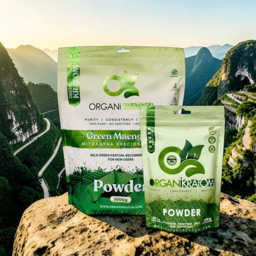 Two organic powder packages on a rocky ledge with mountains in the background.