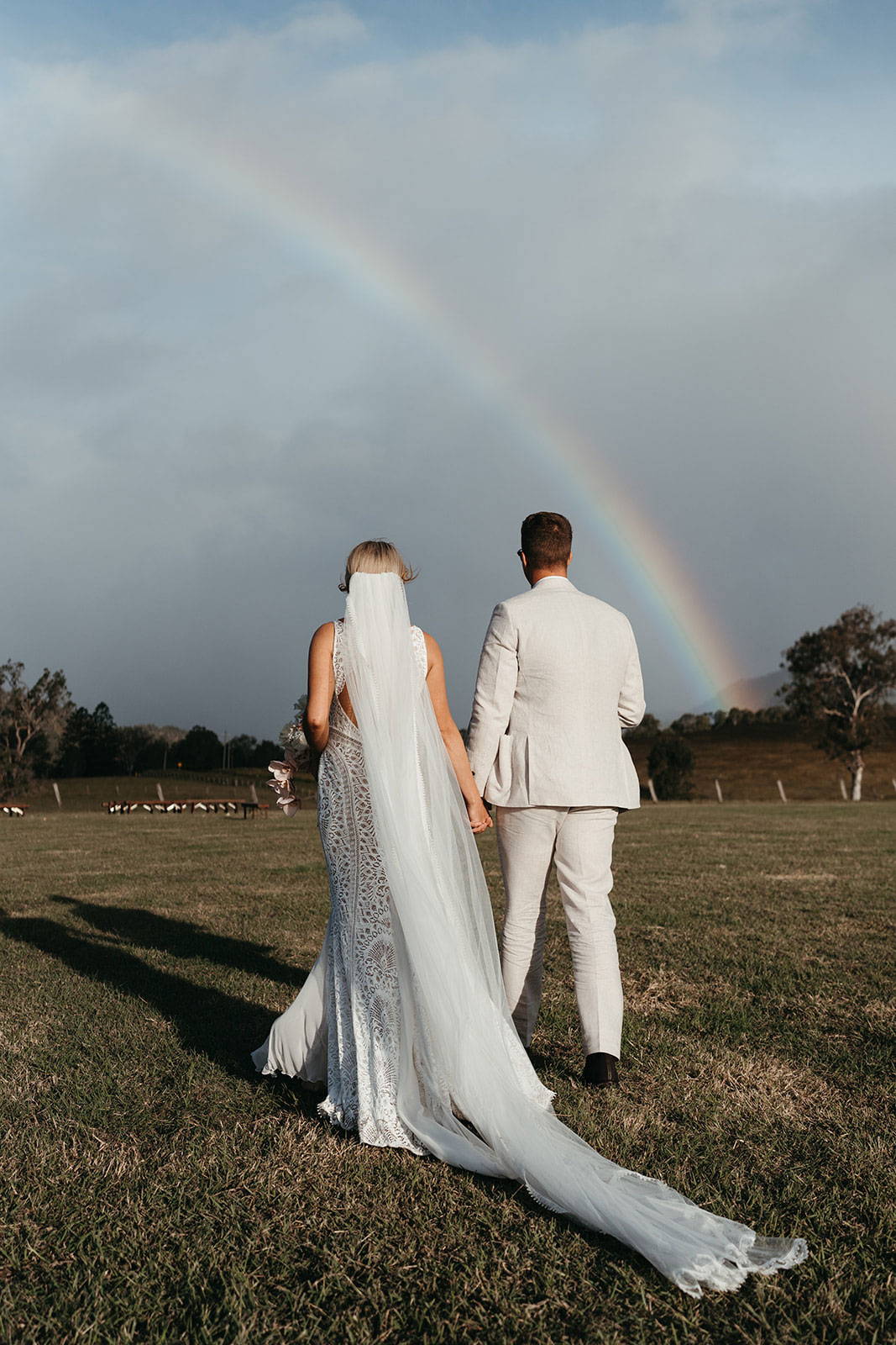 Bride and Groom walking toward rainbow