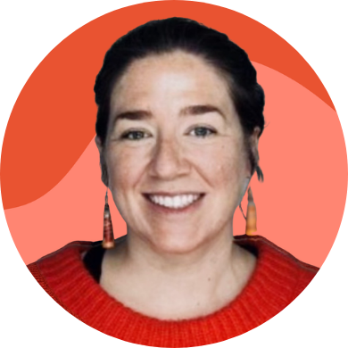 Smiling person in a red sweater with earrings against a colorful background.