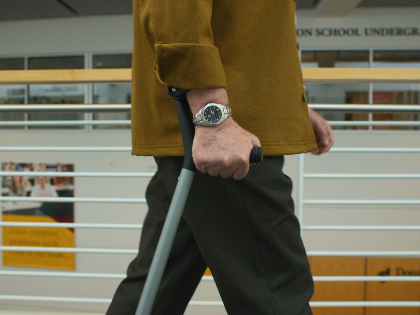 Close-up of a hand gripping the Y-Cane handle with wrist cuff support while walking