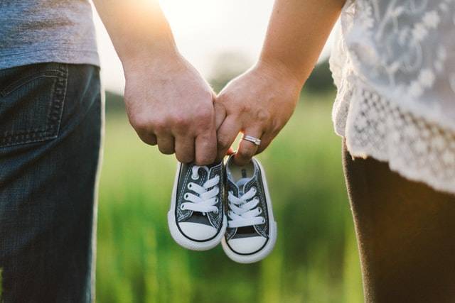 Adults Holding Baby Shoes