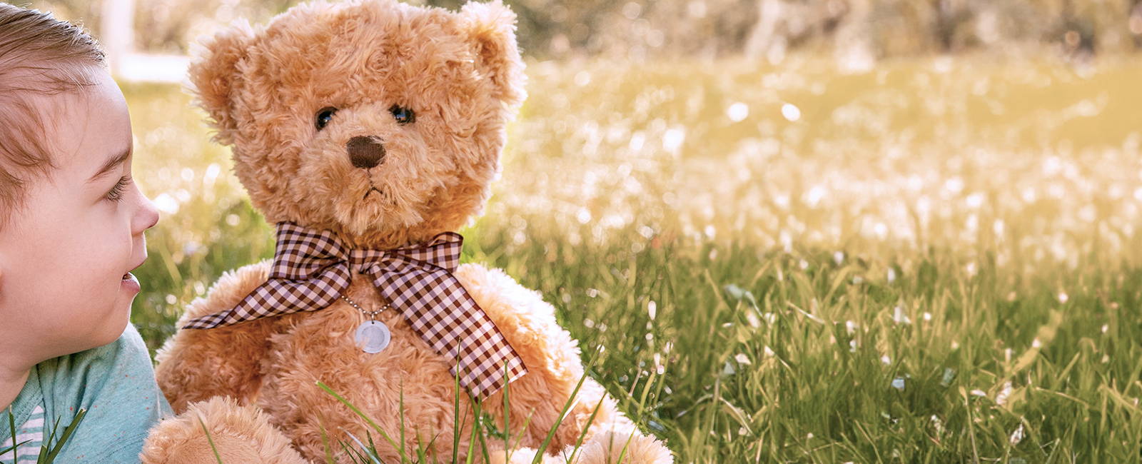 kid sitting with a memorial teddy bear