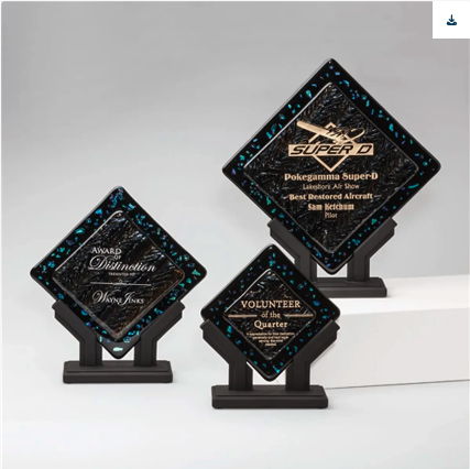 Three decorative awards with engraved messages on stands.