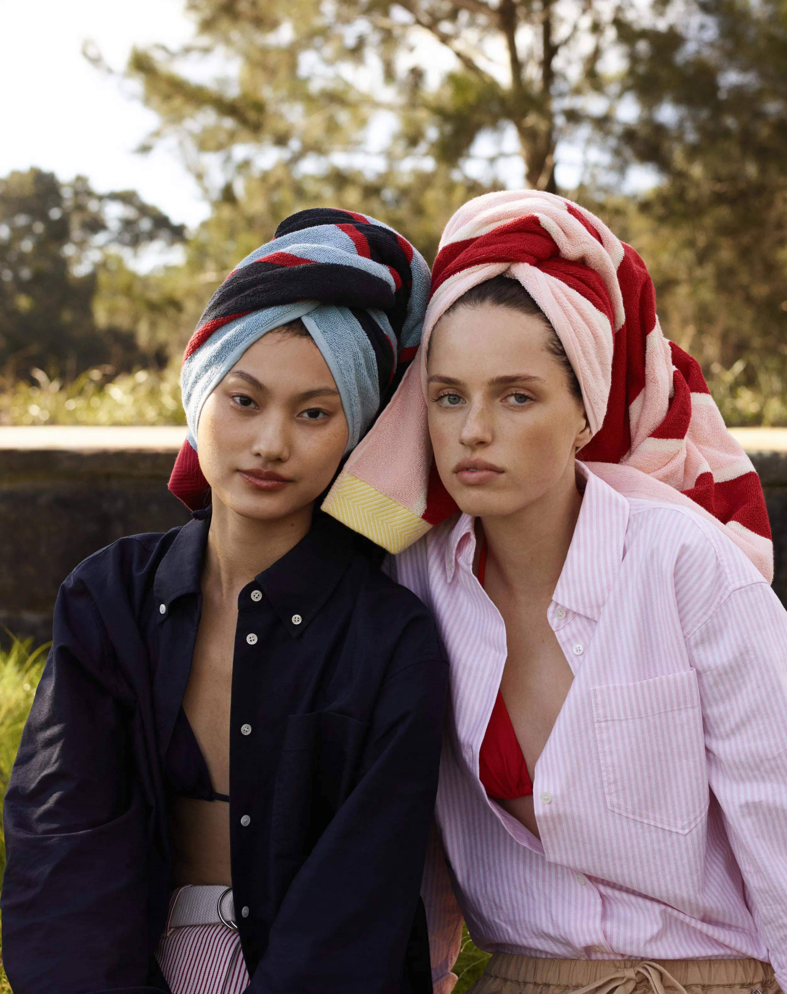 Two women with towels on their heads, posing outdoors.