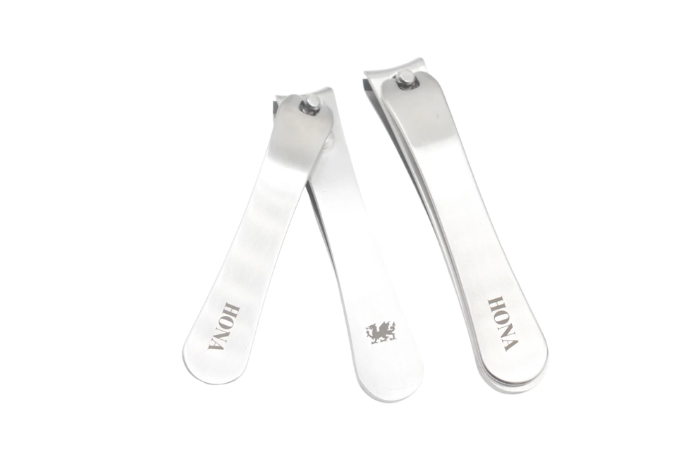 Two metal nail clippers with engraved markings on the handles.