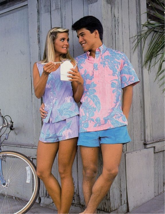 A couple in matching pastel outfits, smiling and holding a takeout container.