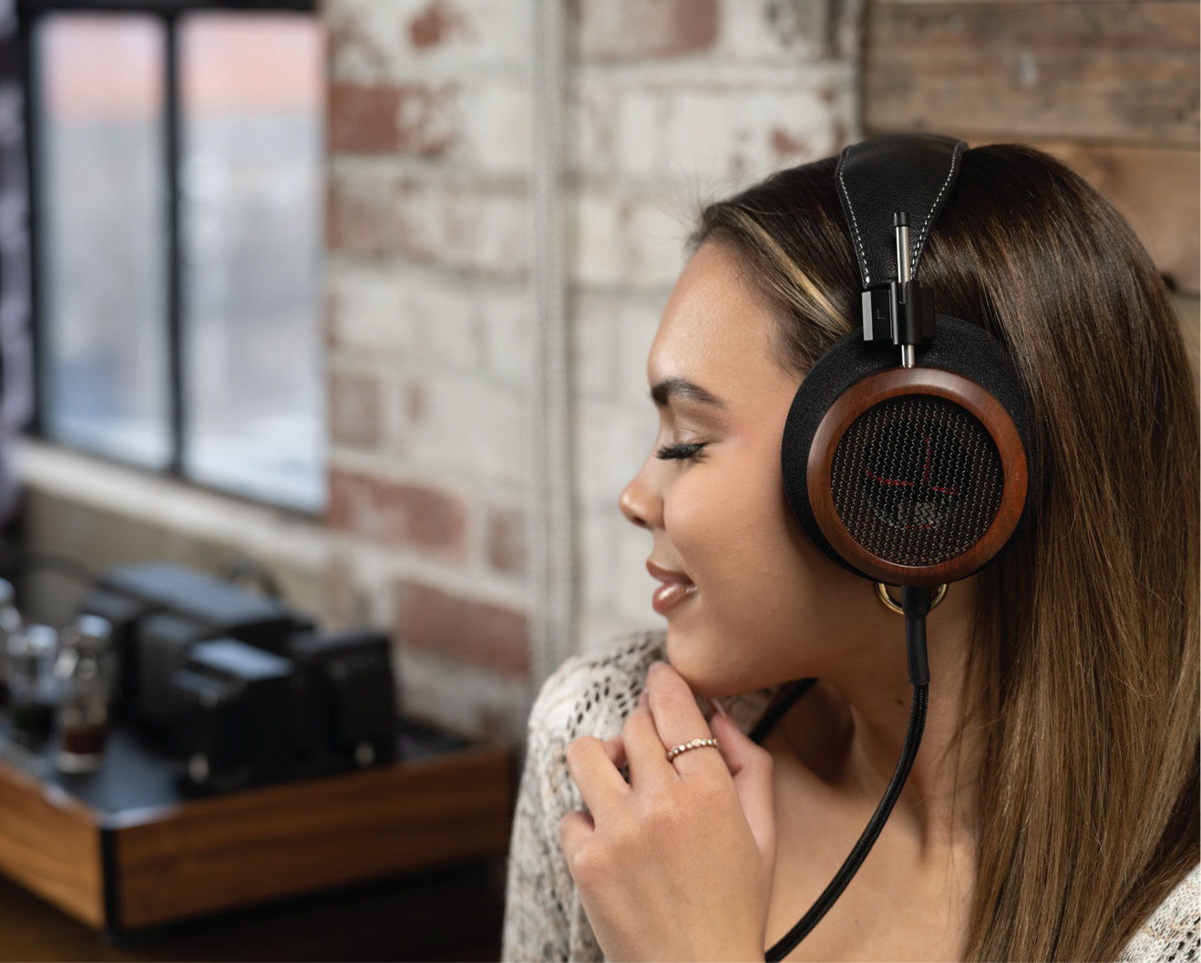 Photo of a woman with blonde hair facing to the left while wearing the Grado S950 headphones. 