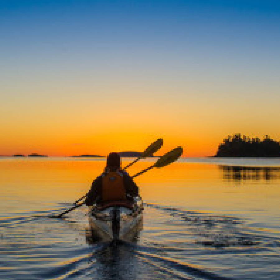 a person in a canoe with paddles on water