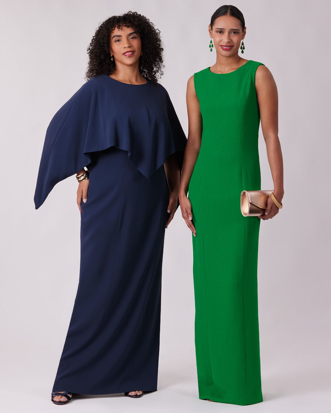 Two women in elegant dresses, one navy blue and one green.