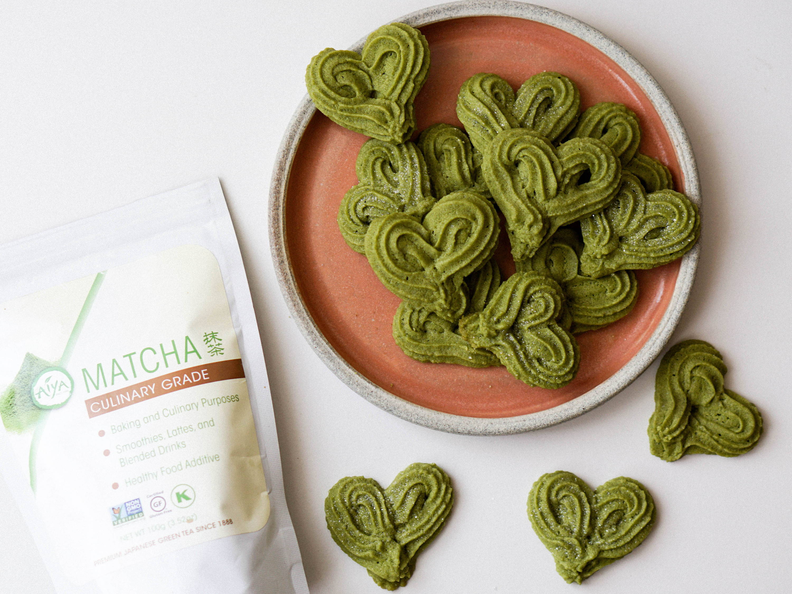 heart-shaped Matcha cookies on a plate with Matcha package beside.