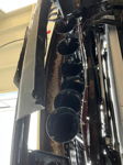 Low-angle view of six black train horns mounted vertically behind front bumper