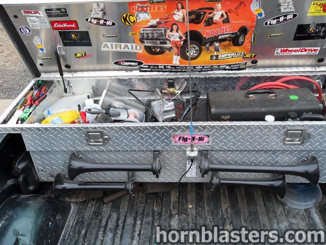 Open toolbox view showing horns, wiring, and air system components for the train horn install