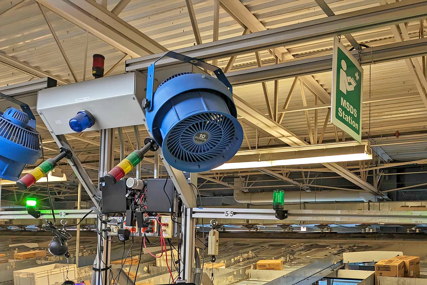 Industrial equipment with blue lights and overhead signage in a warehouse setting.