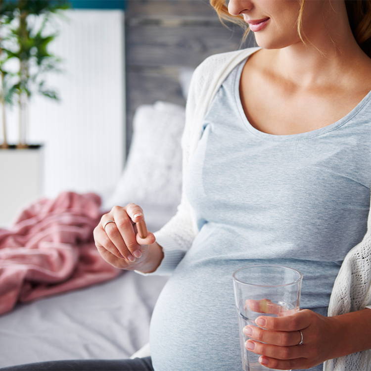 Pregnant Woman Holding Tablet And A Glass Of Water
