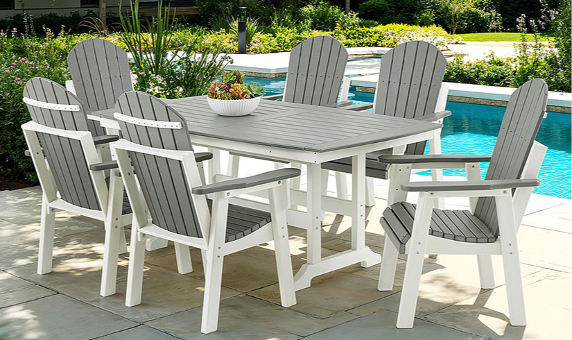 Outdoor dining set with chairs around a table by a pool.
