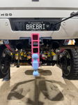 Rear view on shop lift with pink and blue drop hitch on Brianna's Silverado photo 4