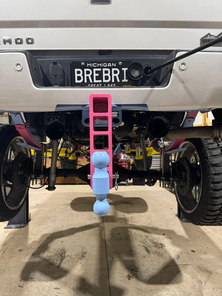 Rear view on shop lift with pink and blue drop hitch on Brianna's Silverado photo 4