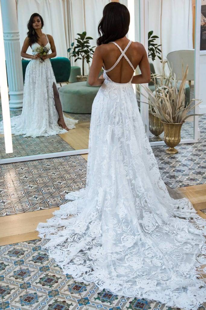 Bride trying on an ivory rose lace dress in bridal shop