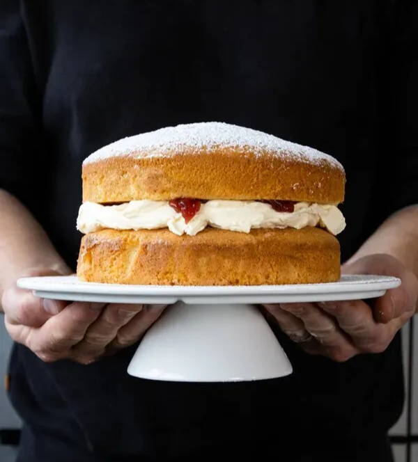 A display stand with a Victoria sponge cake on it.