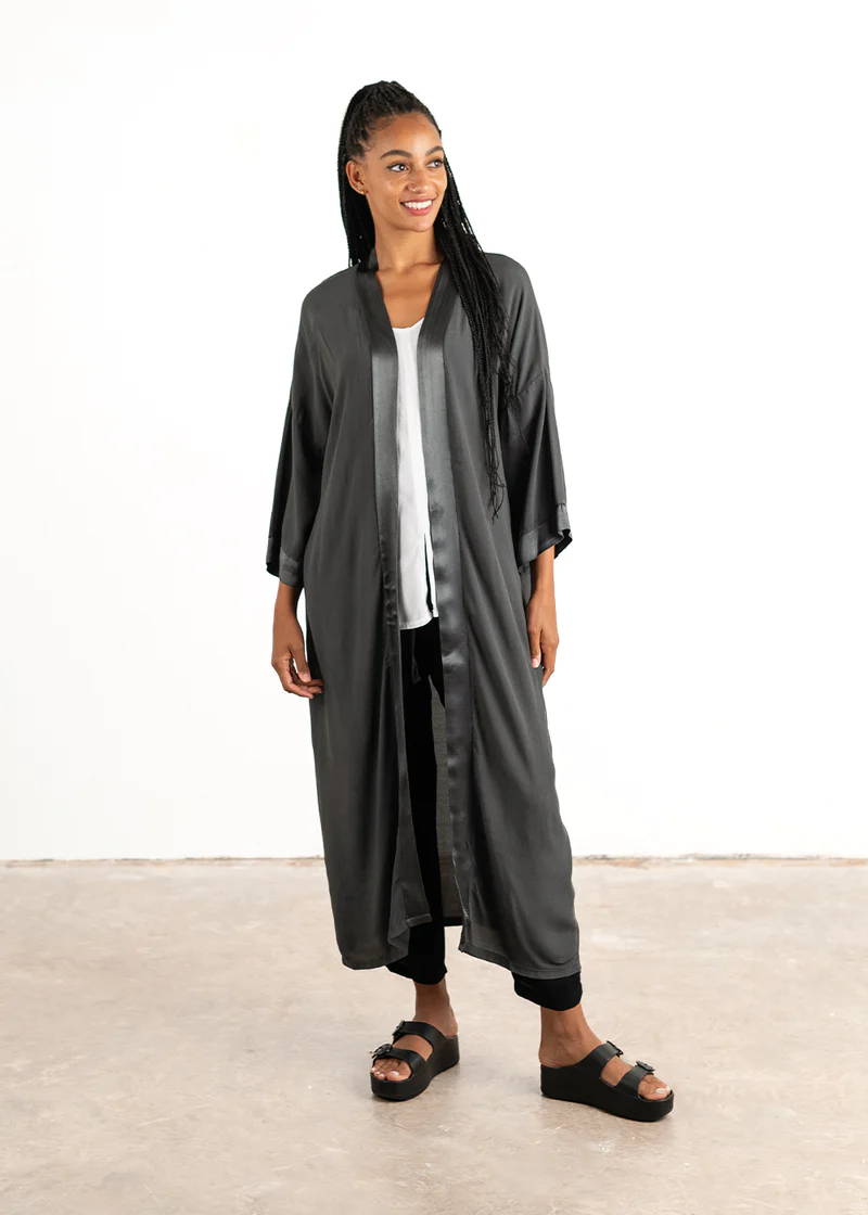 A model wearing a long, midi length satin dark grey kimono