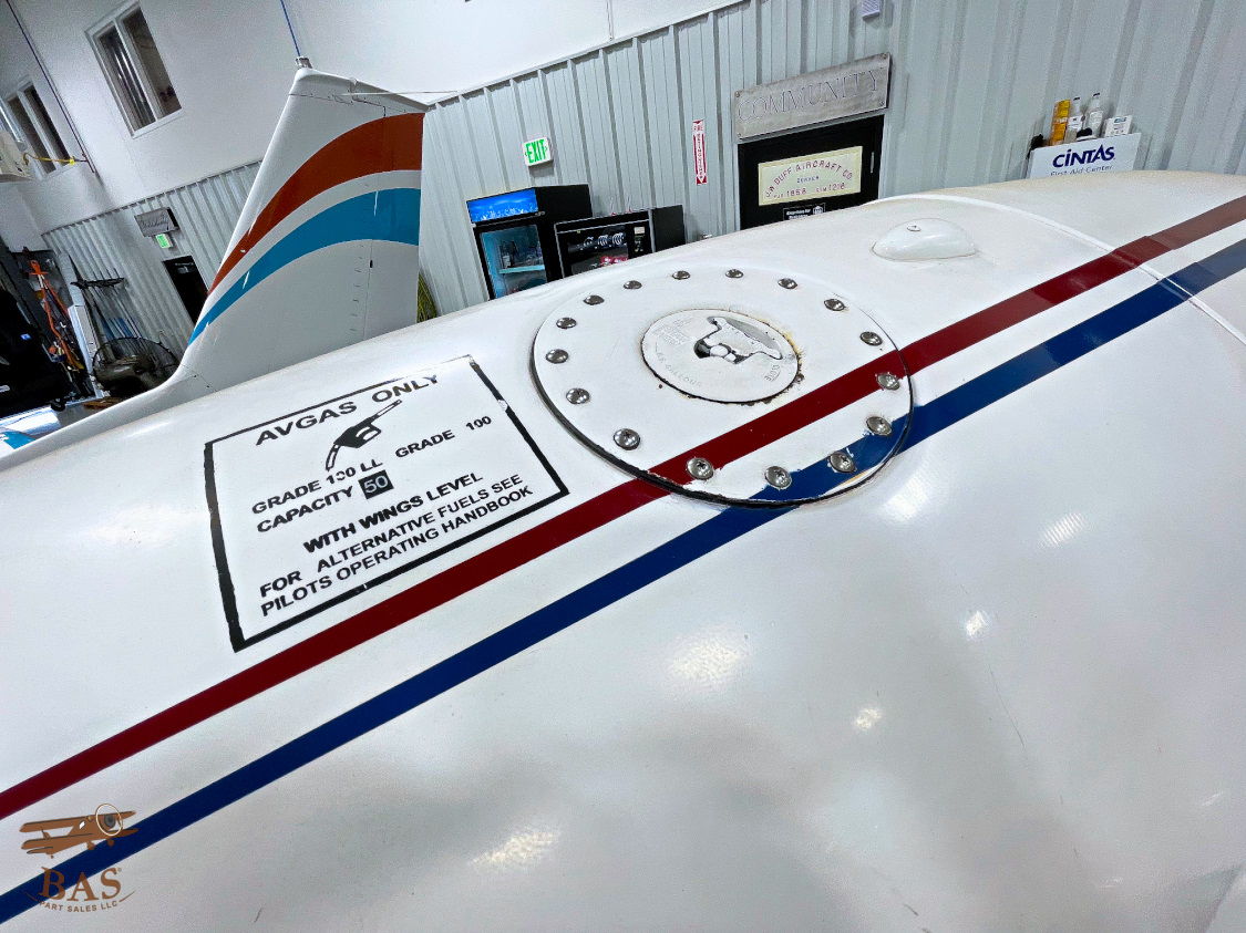 Close-up of an aircraft wing with technical markings and warning labels.