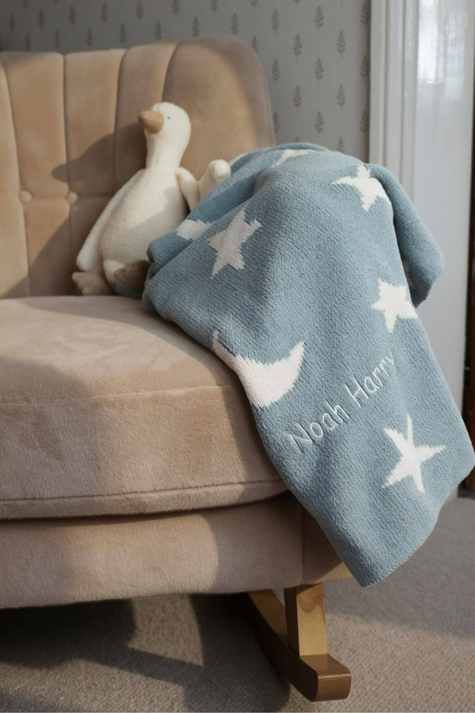 A cozy chair with a blue blanket and a plush toy.